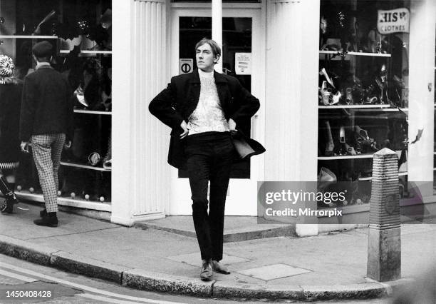 Comedian Peter Cook stands in Carnaby Street during the filming of sketch for Not Only A But Also television show. In the same comedy skit, John...