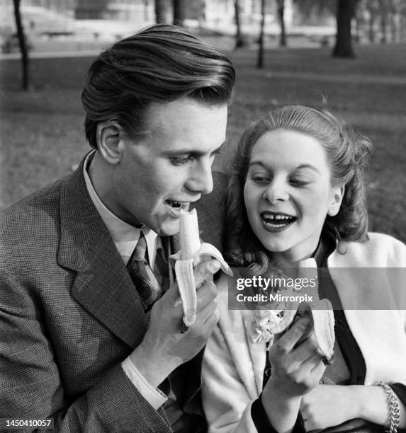 Artist couple Richard and Pat Larter eating a banana on a park bench. February 1953.