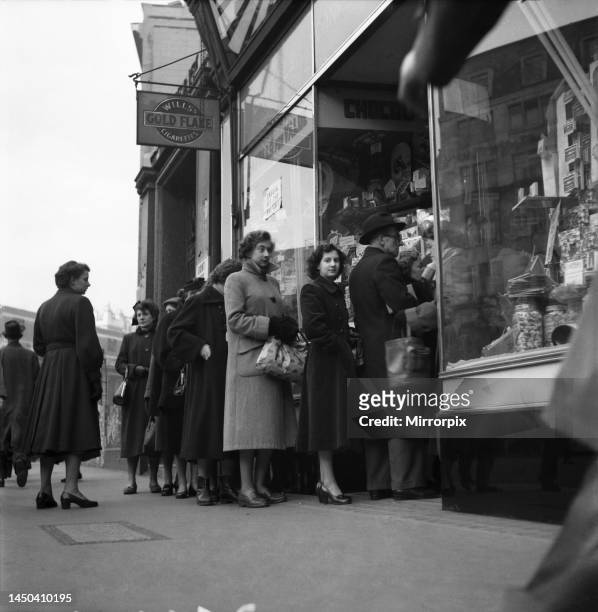 People queuing up outside a confectionary shop after sweets came off the ration following World War Two. December 1952.