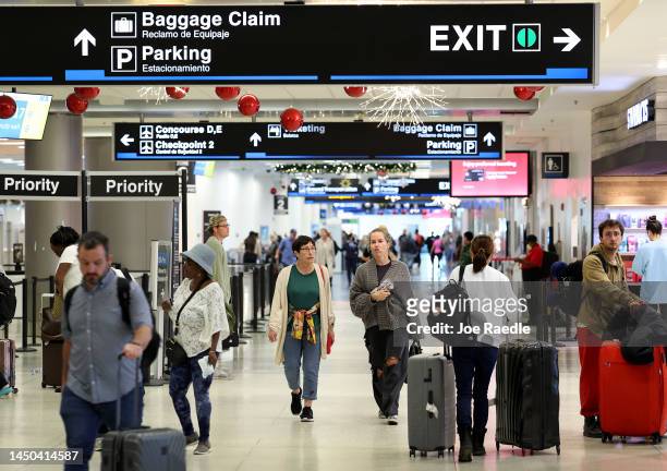 Travelers walk through Miami International Airport on December 19, 2022 in Miami, Florida. Miami International Airport is expecting a busy winter...