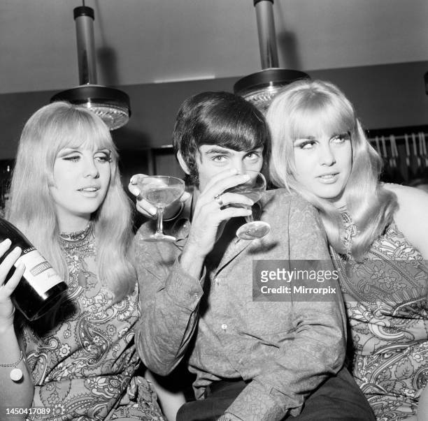 Manchester United footballer George Best celebrates the opening of his fashion boutique with a few glasses of champagne. 14th September 1967.
