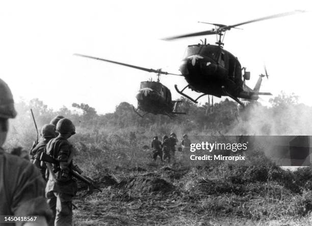 Huey helicopters land in a field during the Vietnam war to pick up casualties sustained by American forces in the battle against the Viet Cong. Circa...