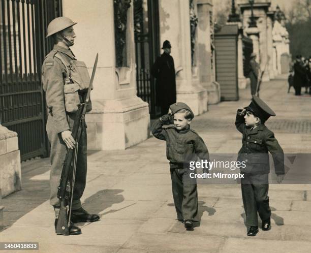 William Knowles and Billy Carter salute the guard standing outside Buckingham Palace.