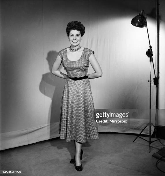 Woman wearing a pinafore dress. November 1952.