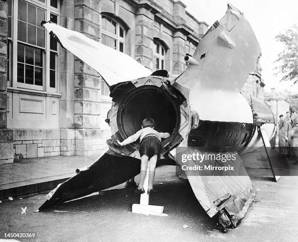 Young boy looks into the exhaust of a captured V2 flying bomb during an open day at Devonport Docks.