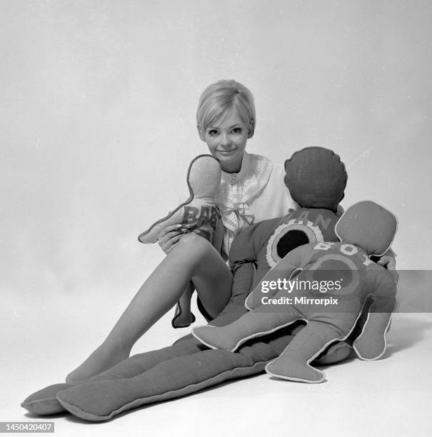 Woman with pillows in the shape of man and child. January 1968.