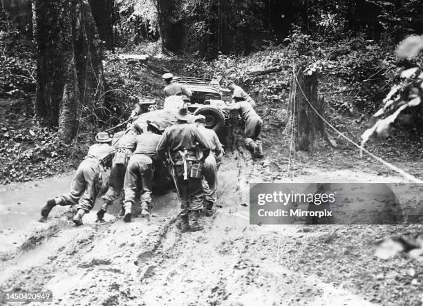 Troops of the British 36th Division advancing from Tagaung push their jeep along a muddy track during the the monsoon.