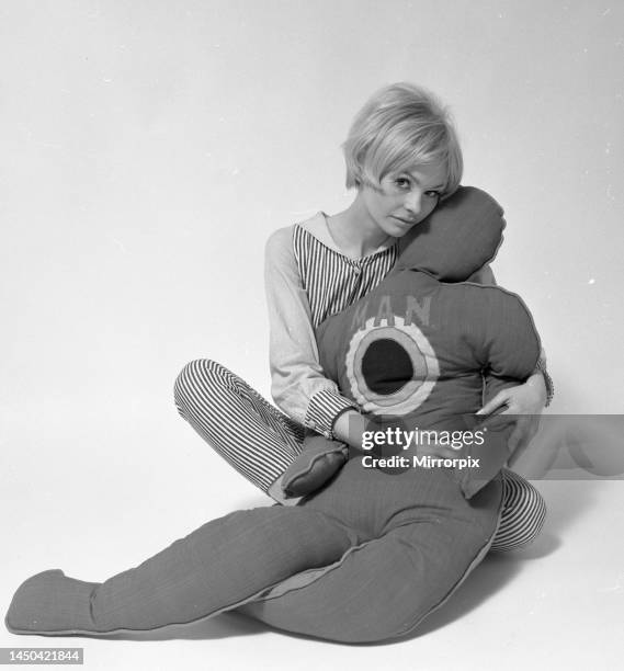 Woman with pillows in the shape of man and child. January 1968.