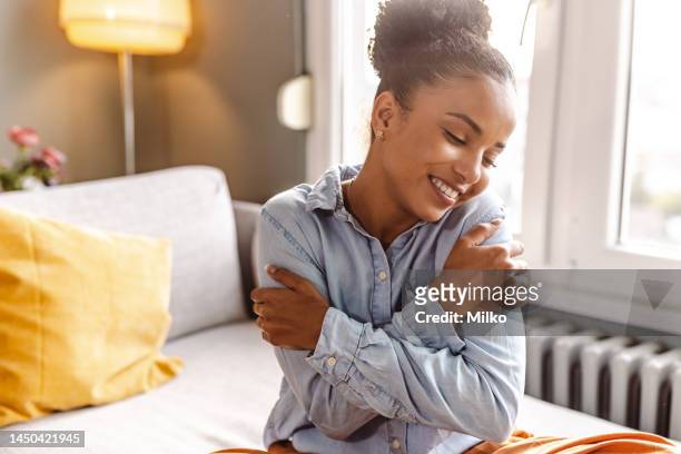 smiling beautiful woman hugging self - krama sig själv bildbanksfoton och bilder