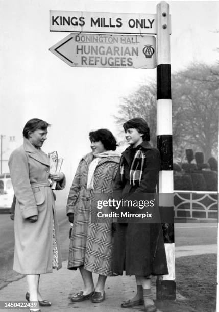 Hungarian RefugeesThree girl guides stand at the sign post for Hungarian Refugees at Castle Donington. November 1956.