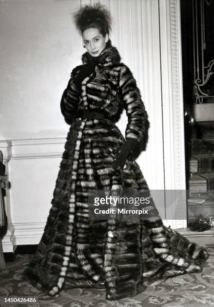 Woman modelling a snug, floor-length coat in fitch fur, one of the eye-catching designs at a fashion show in London. 22nd January 1957.