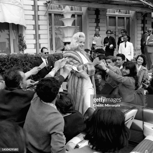 Actress Diana Dors surrounded by autograph hunters at Cannes Film Festival May 1956.
