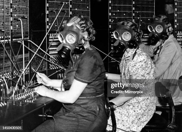 Telephone girls at Whitley Bay Post Office try out the gas masks as they prepare for any eventuality during A. R. P training. August 1938.