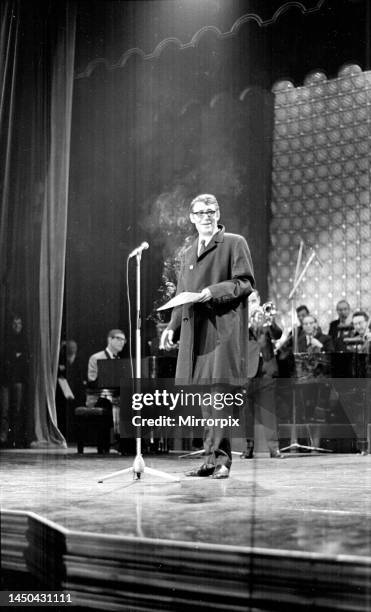 Actor Peter O'Toole at Stars Shine for Jack Hylton holding a cigarette on stage talking to the audience. May 1965.