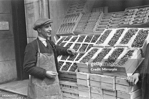 Day in the life of Covent Garden Market. A fruit salesman is selling cherries from his stall. Picture taken 1st July 1948.