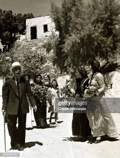 The women of Karpathos in traditional costume, great visitors with armfuls of flowers. Dodecanese Islands, Greece.