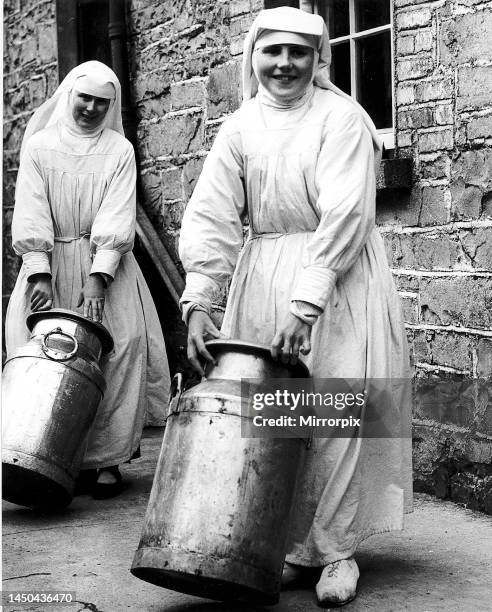 Sister Mona and Sister Benignus of Loughglynne Convent roll in the churns of milk from local farms for their cheese making. 1949.