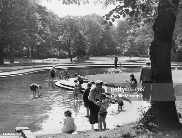 Families enjoying the summer weather in Brandling Park in Newcastle - paddling in the pool.