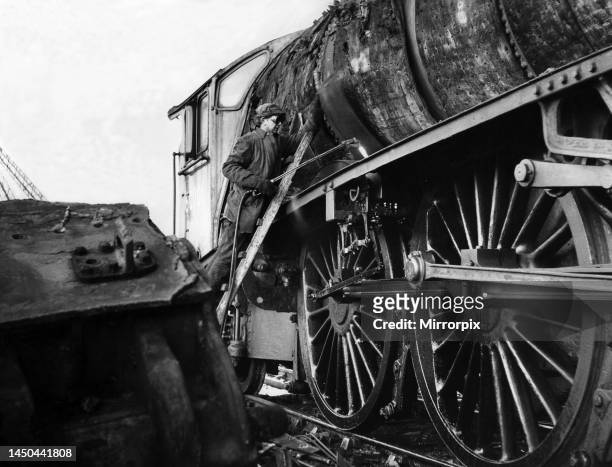 Workman cutting up an old engine at a breakers yard at North Blyth on 5th January 1965.