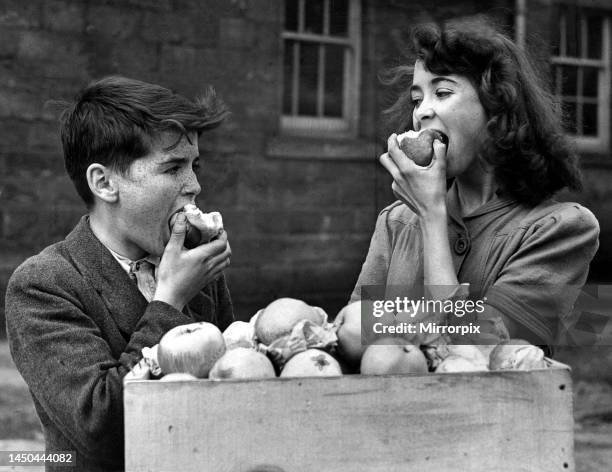 Terence Waite and Eileen Harting enjoy their one of many apples. Mr A. K. Lloyd President of British Columbia Tree Fruits has sent 60 million pounds...