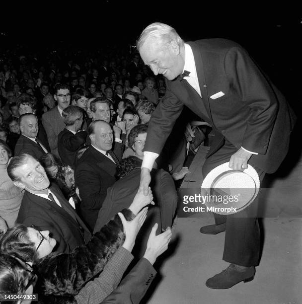Maurice Chevalier with people from the audience at the Palladium. Feb 1968.