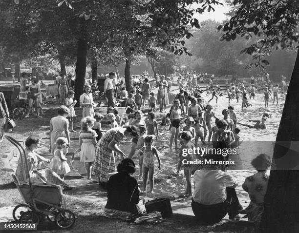 Families enjoying the summer weather in Brandling Park in Newcastle - paddling in the pool.