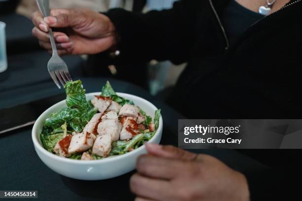 woman enjoys side of caesar salad with grilled chicken - caesar salad stock pictures, royalty-free photos & images