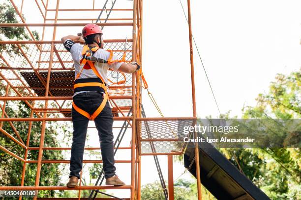 sauveteur grimpant sur un échafaudage sur corde - rope high rescue photos et images de collection