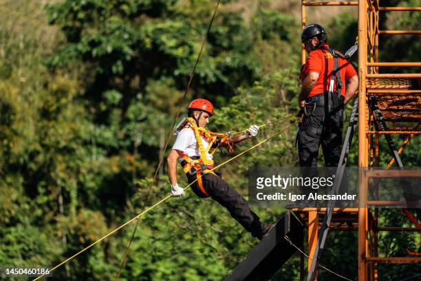 rescuer firefighter climbing with rope - rope high rescue imagens e fotografias de stock
