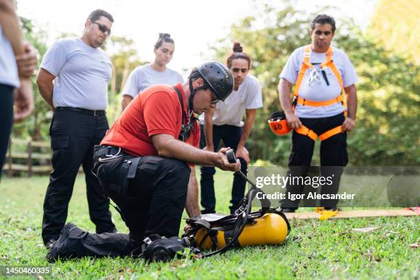 instructor firefighter preparing cylinder backpack - rescue worker stock pictures, royalty-free photos & images
