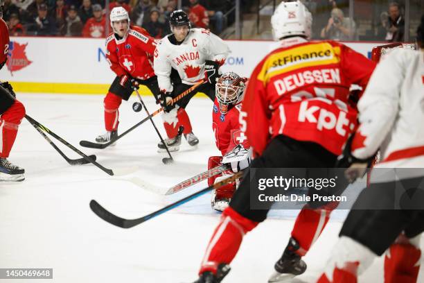 Shane Wright#15 of Team Canada shoots puck at net and Kevin Pasche of Team Switzerland makes a save at Avenir Centre on December 19, 2022 in Moncton,...