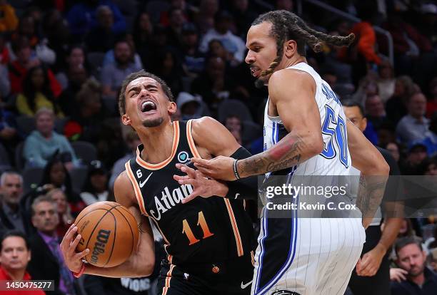 Trae Young of the Atlanta Hawks draws a foul as he drives against Cole Anthony of the Orlando Magic during the fourth quarter at State Farm Arena on...