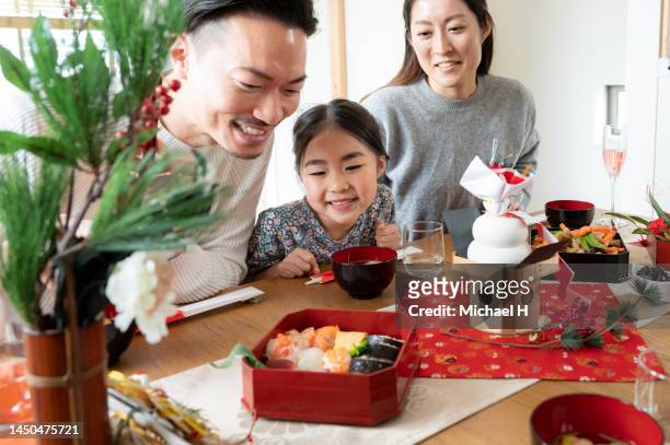 japanese family enjoying traditional new year dishes. - osechi ryori stock pictures, royalty-free photos & images
