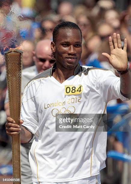 Footballer Didier Drogba carries the Olympic flame through Swindon on May 23, 2012 in Wiltshire, England. The Olympic Flame arrived in the UK last...