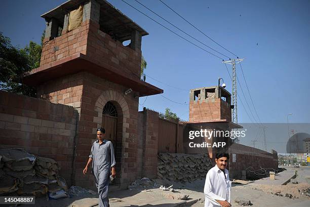Pedestrians walk past the Peshawar central jail where Pakistani surgeon Shakeel Afridi, who worked for US intelligence, was moved after the verdict...