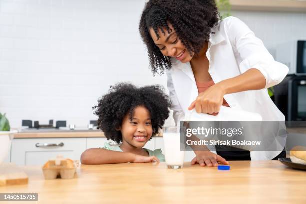 snack time. happy black mother - milk family stock pictures, royalty-free photos & images