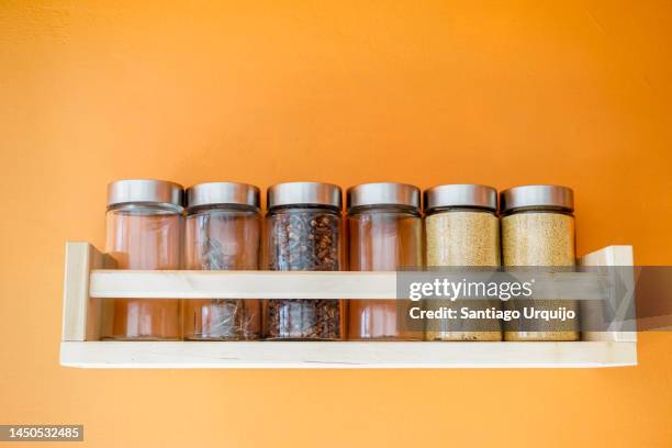 spices jars on wooden shelf - specerij stockfoto's en -beelden