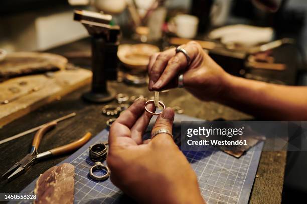 hands of craftswoman repairing ring at workbench - jeweller bildbanksfoton och bilder