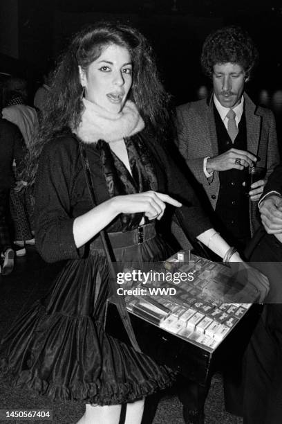 Young woman, dressed as a cigarette girl from the 1950s, holds a tray of cigarette packets at the club Heartbreaker, in New York City