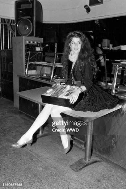 Young woman, dressed as a cigarette girl from the 1950s, holds a tray of cigarette packets at the club Heartbreaker, in New York City