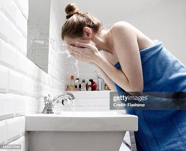 woman splashing face with water - woman washing face stockfoto's en -beelden