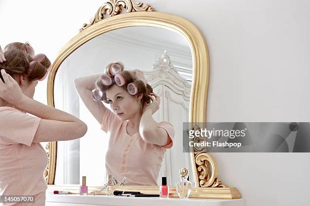 woman putting curlers in her hair - dressing table stock pictures, royalty-free photos & images