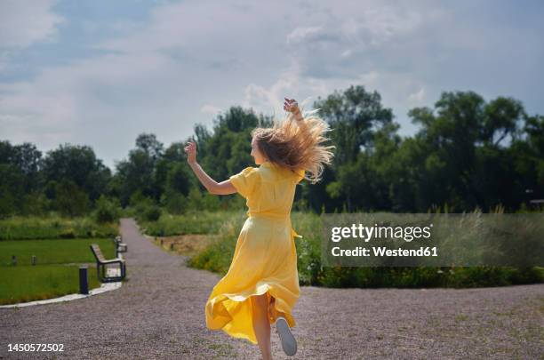 happy woman dancing and having fun in park on sunny day - sunny back fotografías e imágenes de stock