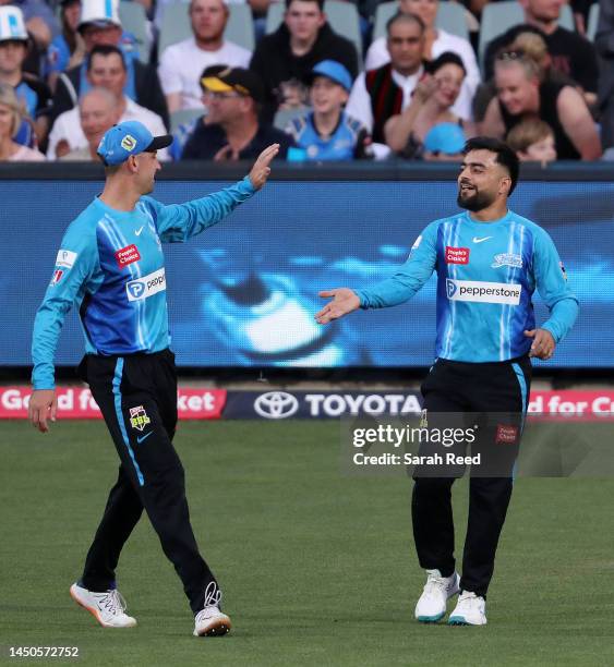 Adam Hose of the Strikers congratulates Rashid Khan of the Strikers after he took the catch to dismiss Oliver Davies of the Thunder for 42 runs off...