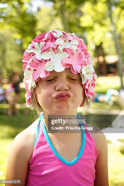 a young girl in a swim cap makes a silly face. - swimming cap stock pictures, royalty-free photos & images