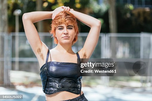 Confident young woman wearing corset showing armpit hair Confident young woman wearing corset showing armpit hair