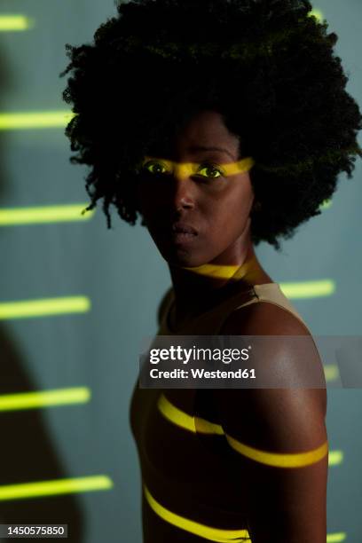 woman with afro hairstyle standing with yellow stripes on her - human body foto e immagini stock