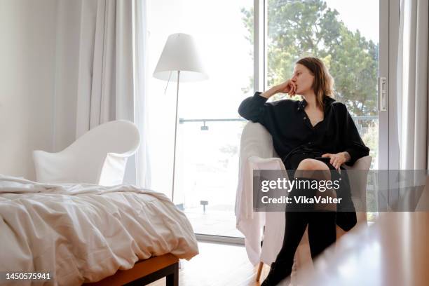 femme dans une chambre d’hôtel clairsemée - knee length photos et images de collection