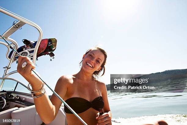 a young woman smiling on a wakeboard boat in idaho. - pend orielle lake stock pictures, royalty-free photos & images