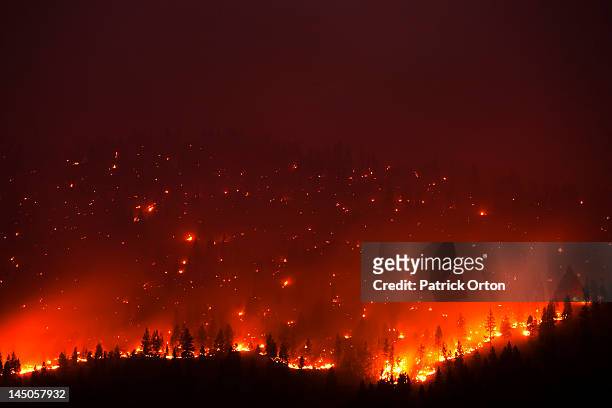 a forrest fire burning the side of a mountain in montana. - incendio forestal fotografías e imágenes de stock